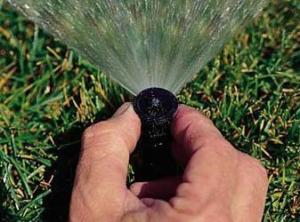 Irrigation contractor in Duncanville TX adjusts a sprinkler head